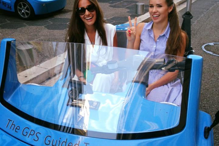 Deux femmes souriantes dans une NiceCar bleue