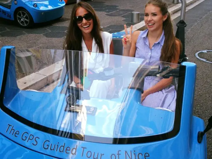 Deux femmes souriantes dans une NiceCar bleue