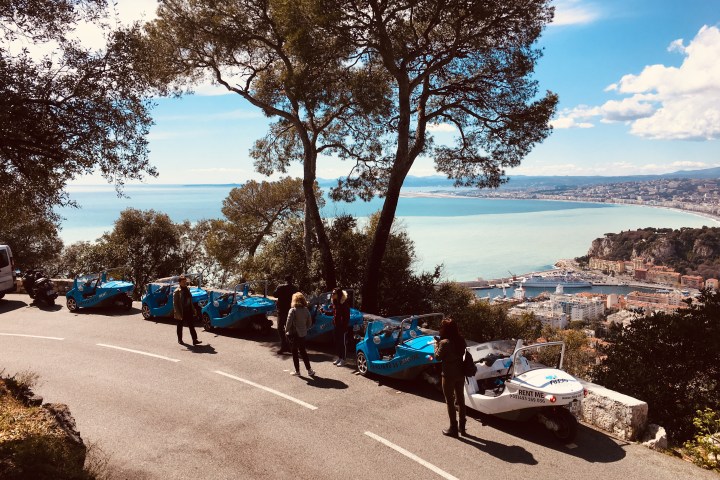 Certaines NiceCar bleues garées près d´un mur avec la mer au fond