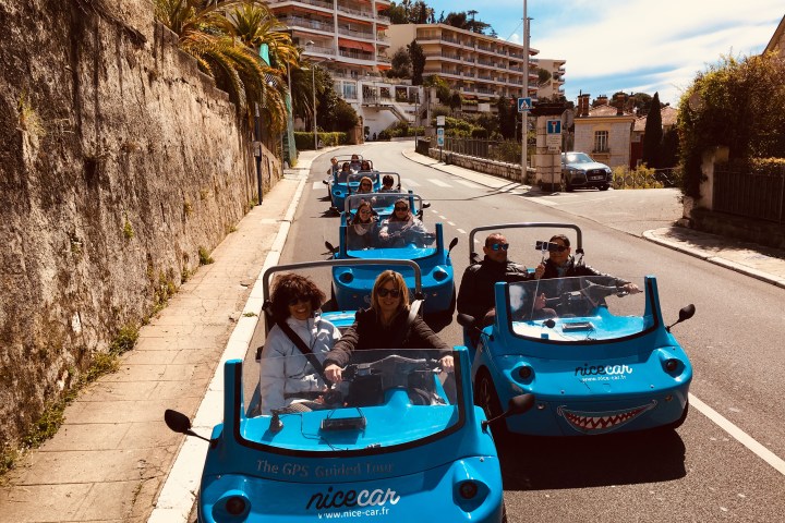Cinq NiceCar bleues à deux personnes sur la route