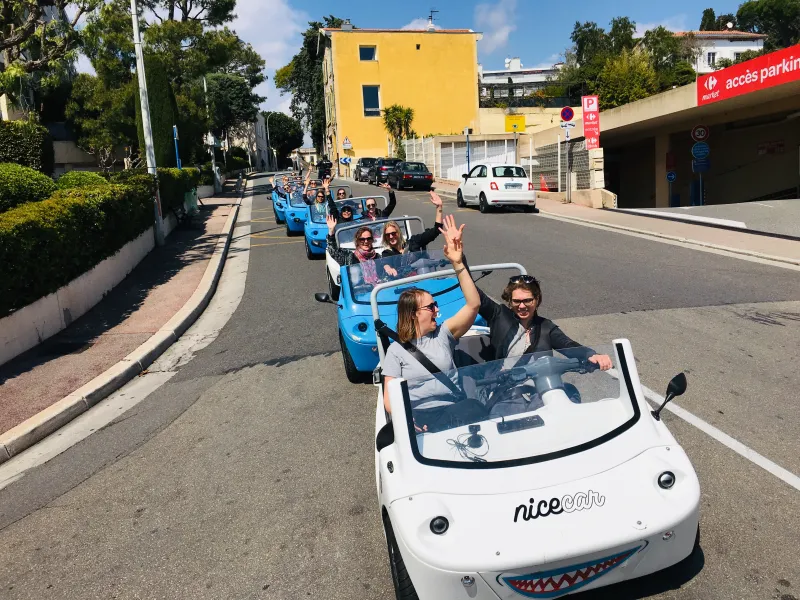 Cinq NiceCar bleues à deux personnes sur la route